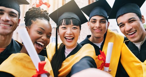College students taking selfie for graduation at campus, celebrating diversity and achievement