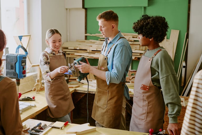 Multiethnic young adults learning woodworking, examining power tool during hands-on workshop training. Suitable for vocational education, teamwork, skilled trades promotion